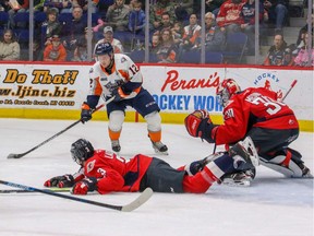 Flint's Jake Durham (12) moves in for a shot on Windsor goalie Xavier Medina (30) while Luke Boka (61) and Grayson Ladd (3) move in to defend.      Todd Boone / Flint Firebirds