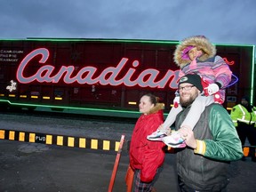 Starr Harrington, left, Jason Berlasty holding his daughter Randi Berlasty, 4, check out the CP Holiday Train on a chilly evening near Janette Avenue Saturday. Canadian Pacific Railway uses two trains to complete the coast-to-coast Holiday Train journey.