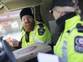 Emergency pizza. EMS paramedics Trevor Iles, left, and Allison Baldwin enjoy a complimentary Christmas pizza from Windsor's Oven 360 on Grand Marais Road, on Dec. 25, 2019.  The restaurant was giving out free pizzas to first responders working Christmas Day.