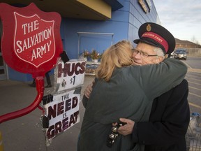 Salvation Army Christmas Kettle bell ringer Gord Dickerson gives a hug to shopper Theresa Sauve outside the Walmart in South Windsor Tuesday, Dec. 17, 2019.