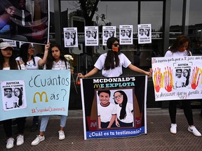 People protest outside of a closed McDonald's restaurant, after the the deaths of two teenaged employees, in Lima, Peru, Dec. 21, 2019.