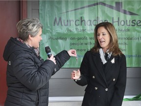 Sandy Murphy, left, president of  Murchada House,  hands the keys Friday to a brand new house in Cottam to Karen Bolger, executive director of  Community Living Essex County, which will staff and run the house for four youths with exceptional needs.