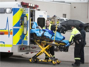 Paramedics and Windsor firefighters work at the scene of a two-car collision at Tuscarora and McDougall streets Friday.