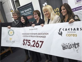 WINDSOR, ON. DECEMBER 19, 2019 -- The S'Aints band in collaboration with St. Clair College and Caesars Windsor announced the grand total of proceeds raised by the 2019 Sleighing Hunger charity concert on Thursday, December 19, 2019 at the Unemployed Help Centre in Windsor, ON. From left, Jeff Burrows, from The S'aints, Patti France, president, St. Clair College, Brenda LeClair, executive director, Chatham Outreach for Hunger, June Muir, president, Windsor Essex Food Bank Association and Mary Riley, VP of Marketing, Caesars Windsor, pose with the ceremonial cheque for $75,267.