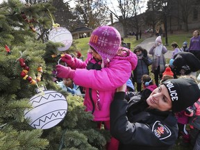 Students from General Brock Public School and the Westview Freedom Academy helped decorate a Christmas tree at the Mackenzie Hall's park on Thursday, December 5, 2019 in preparation for this upcoming weekend's Miracle in Sandwich event. The youngsters are shown having a hot chocolate and cookie break during the event. Windsor Police Const. Lauren Brisco gives Islam Al Zoubi, 5, a kindergarten student at Brock a lift as she decorated the tree.