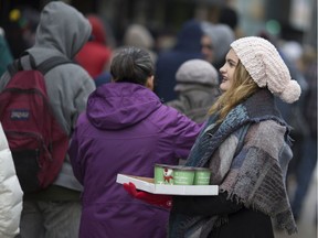 In this file photo from 2016, Sarah Mikhail, daughter of Lou Mikhail, hands out free hot coffee to people lined up along the 300 block of Ouellette Avenue for the Mikhail Holdings turkey giveaway in downtown Windsor.