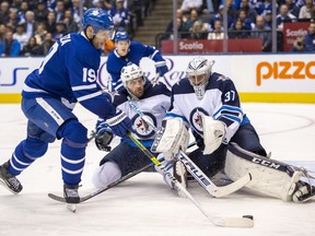 Maple Leafs centre Jason Spezza (19) shoots on Jets goaltender Connor Hellebuyck as defenceman Tucker Poolman closes in during seoncd-period action in Toronto on Wednesday January 8, 2020. (FRANK GUNN/THE CANADIAN PRESS)
