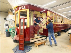 RM Restorations technicians Serge Legare, left, and Jamie Bourdeau install sliding doors made of cherrywood on Windsor's Streetcar No. 351 Wednesday. Nearing completion, Streetcar No. 351 will be a unique showpiece for the region due to the workmanship and fine details of the rebuild.