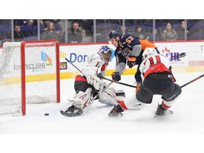 Flint Firebirds' captain Ty Dellandrea tucks home the game-winning goal against Windsor Spitfires' goalie Kari Piiroinen on Saturday as Windsor's Egor Afanasyev tries to defend.