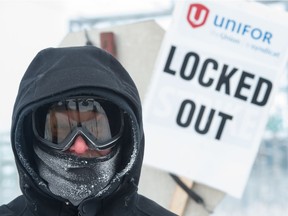 A picketer stands outside the Co-op Refinery Complex in Regina, Saskatchewan on Tuesday afternoon as temperatures hovered near -30C.