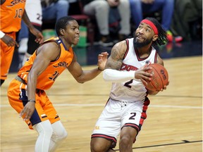 Windsor, Ontario. January 17, 2020.  Windsor Express DeShaun Thrower, right, drives against Island Storm Darnell Landon in NBL Canada action from Windsor's WFCU Centre Friday.