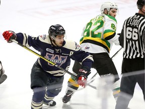 Windsor Spitfires Chris Playfair avoids a check from London Knights Jason Willms, right, in OHL action  at the WFCU Centre on Thursday.