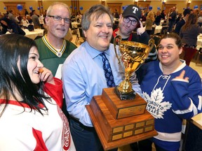 Holding the Battle of the Brains trophy, quiz master and local trivia guru Jack Ramieri, centre, pre-games with Danielle Laprade, left, and Julia Vieceli, right, and other members of Team Dionysus Away on Friday, Jan. 24, 2020, at the Ciociaro Club. This year's 9th annual fundraising event attracted almost 1,200 trivia fans in 148 teams, with proceeds of the night supporting local programs and services of the Alzheimer Society of Windsor & Essex County.