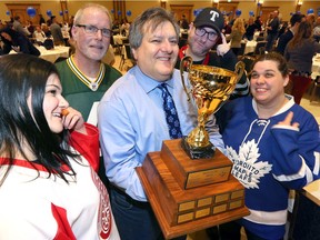 Holding  last year's Battle of the Brains trophy, quiz master and local trivia guru Jack Ramieri, centre, pre-games with Danielle Laprade, left, and Julia Vieceli, right, and other members of Team Dionysus Away on Jan. 24, 2020, at the Ciociaro Club. The 9th annual fundraising event attracted almost 1,200 trivia fans in 148 teams in 2020.