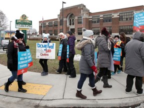 Public elementary school teachers, family and supporters  walk the line near John Campbell Public School during their one-day strike Wednesday.