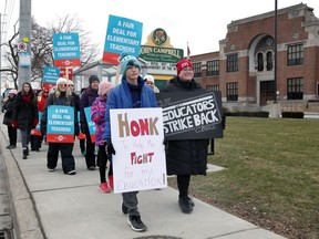 Teacher Karen Kozma, right, walks the picket line with her nephew Alex Kozma and dozens of other teachers, students and supporters at John Campbell Public School on Tecumseh Road East Wednesday.