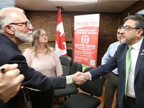 Thomas Rolfe, left, executive director of Hiatus House is greeted by Chief Consul Alberto Bernal, right, Consulate of Mexico office in Leamington on Thursday.  Behind, Debra Fowler, residental therapist with Hiatus House, joins the ceremony.