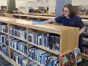 Windsor Public Library custodian Irena Obradovich cleans book shelves at the new temporary location of the Central Branch of Windsor Public Library in the Paul Martin Building at 185 Ouellette Ave. Friday.