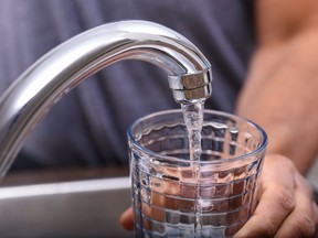 A boil water advisory has been issued for residents in Wheatley and some Hand with drinking glass filling tap water from kitchen faucet, home and lifestyle concept.