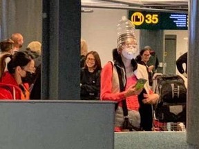 Some airline passengers have been spotted at Vancouver International Airport wearing water bottles on their heads to shield themselves from germs. (Facebook)