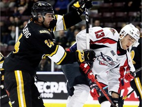 Sarnia Sting's Marko Jakovljevic (24) hits Windsor Spitfires' Will Cuylle (13) in the second period at Progressive Auto Sales Arena in Sarnia, Ont., on Sunday, Jan. 26, 2020. Mark Malone/Chatham Daily News/Postmedia Network