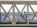 The cyclist enjoys the sunny weather on April 9, 2019 as he crosses a bridge over the promenade of the Herb Gray Road.