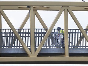 A cyclist enjoys the sunny weather April 9, 2019, as he crosses a bridge on the Herb Gray Parkway Promenade.
