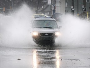 A motorist ploughs through a flooded section of Howard Avenue near Tecumseh Road East on Saturday, Jan. 11, 2020.