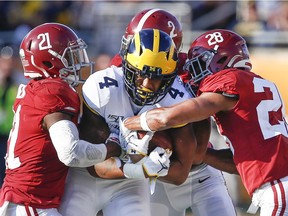 Michigan Wolverines wide receiver Nico Collins is tackled by Alabama Crimson Tide's Jared Mayden, defensive back Patrick Surtain II and defensive back Josh Jobe during the second half of the Citrus Bowl at Camping World Stadium on Wednesday in Orlando, Fla. The Wolverines led 16-14 at halftime, but they failed to score in the second half of a 35-16 loss to the Crimson Tide. Reinhold Matay/USA Today