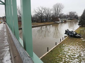 The wreckage of a dark blue Cadillac on the east side of the Little River by the bridge on Wyandotte Street East on Jan. 25, 2020. Police have determined the car landed there after launching from the west bank of the river.