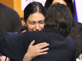 Two people who attended a University of Windsor memorial service for five colleagues killed in the air crash in Iran,   embrace after the event on Friday.