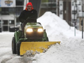 Tom Appleyard, a City of Windsor employee, clears some snow on Pitt Street in downtown Windsor on Saturday, Jan. 18, 2020.