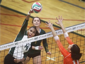 Keyome Ellis, left, of St. Clair College spikes a ball by the defence of Dakari Gennaro of Mohawk College during their match on Saturday.