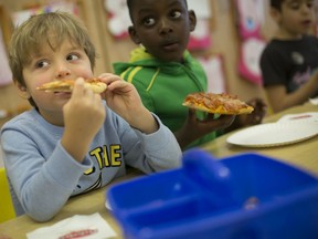 Alex Hansen, left, and Gabriel Lungu, students in Mme Kristen and Mme Rachelle's junior and senior kindergarten class at École Élémentaire Catholique Monseigneur Jean Noël, enjoy some pizza from Antonino's Original Pizza, Monday, January 13, 2020.