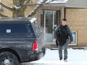 A London police officer leaves an apartment at 63 Wellington Rd., where city police assisted their Brantford counterparts in arresting homicide suspect Shajjad Hossain Idrish, 22, on Friday. DALE CARRUTHERS / THE LONDON FREE PRESS
