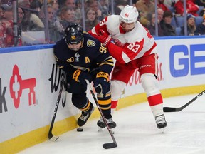 Marcus Johansson of the Buffalo Sabres and Trevor Daley of the Detroit Red Wings battle for a loose puck along the boards during the second period at KeyBank Center on February 11, 2020 in Buffalo, New York.