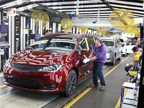 Inspector Frank Calzavara is shown with a Chrysler Pacifica Hybrid in velvet red in the 'final car' area of FCA Canada's Windsor Assembly Plant.
