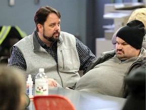 Downtown Mission Executive Director Ron Dunn, left, speaks Joe Koos, 44, right, about changes to the Mission's operating hours Wednesday.