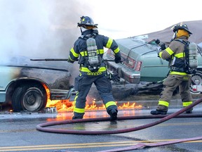 Windsor firefighters work to extinguish flames which destroyed a vintage mid-seventies Ford LTD on Riverside Drive East Tuesday.  Several other Ford LTDs were parked nearby.  Riverside Drive East traffic in both directions was re-routed for less than a hour.