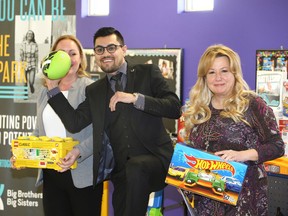 Local entrepreneur and philanthropist Sam Sinjari, centre, has some fun with a toy football after his  Family Day donation to Becky Parent, right, of Big Brothers Big Sisters Windsor and Loran Dutka, behind, of Windsor Essex Children's Aid Society Wednesday.   Sinjari donated dozens of toys, sporting goods, crafts and games which will assist both agencies with programs and service delivery.