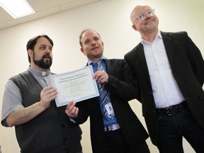 Downtown Mission Executive Director Ron Dunn (left) and Mark Gillett, the Enterprise Program's coordinator (right) present Steven Parker (middle) the graduation certificate he earned on Thursday, Feb. 20, 2020 for completing the Enterprise Program.