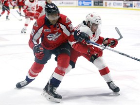 Windsor, Ontario. February 27, 2020. Windsor Spitfires' forward Cole Purboo, left, battles Sault Ste. Marie Greyhounds' defenceman Robert Calisti during Thursday's OHL game at the WFCU Centre.