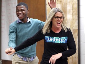 Kelvin Doe, 23, self-taught engineer from Sierra Leone in Africa, celebrates with St. Rose Elementary teacher Kim Sidi after she completed one of Doe's electronic games on Friday, Feb. 28, 2020.