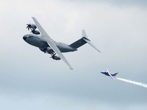 A French military Airbus A400M flies next to Patrouille de France jet (R) on June 12, 2015 during the flight display preparations three days prior to the opening of the International Paris Airshow at Le Bourget.