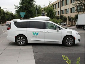 (FILES) In this file photo taken on May 08, 2019, a Waymo self-driving car pulls into a parking lot at the Google-owned company's headquarters in Mountain View, California.