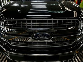 (FILES) This file photo shows a Ford logo on a front bumper as Ford 2018 and 2019 F-150 trucks sit on the assembly line at the Ford Motor Company's Rouge Complex in Dearborn, Michigan. - While Wall Street continued to ogle Tesla's skyrocketing valuation on February 5, 2020, shares of Ford and General Motors were under pressure after reporting fourth-quarter losses.The year's dreary finale for two of Detroit's "Big Three" underscored anew the vast existential gulf between twenty-first century Tesla and two industrial-age giants that are rebooting themselves for a future that emphasizes electric cars and autonomous driving.