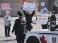 Advocates for the homeless briefly blocked traffic near Windsor City Hall on Friday, Feb. 21, 2020. Here, a Windsor Police Service officer approaches members of the Angels for the Homeless organization during their demonstration. The street was cleared peacefully.