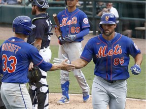 New York Mets outfielder Tim Tebow celebrates with second baseman Max Moroff after hitting a two run home run against the Detroit Tigers during the fifth inning at Publix Field at Joker Marchant Stadium.