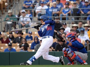 Los Angeles Dodgers right fielder Mookie Betts bats against the Chicago Cubs during the first inning of a spring training game at Camelback Ranch.