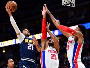 Denver Nuggets guard Jamal Murray shoots the ball over Detroit Pistons guard Derrick Rose  and forward Christian Wood in the first quarter at the Pepsi Center.